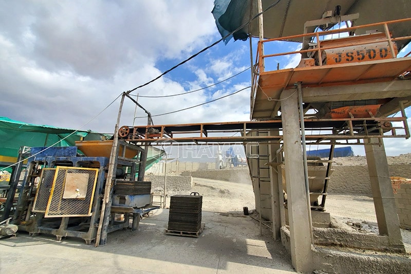 La bétonnière JS500 alimente en béton la machine à blocs